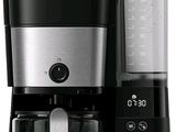 une cafetière noire et argentée équipée d'un mixeur