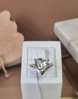 une bague en diamant dans une boîte blanche posée sur une table