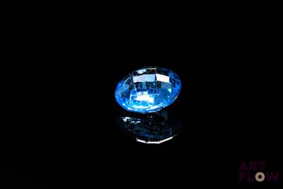 a close up of a blue diamond on a black surface