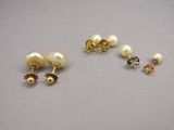 trois paires de boucles d'oreilles en perles et en or posées sur un fond gris