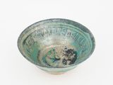 a green bowl with a black and white design on it