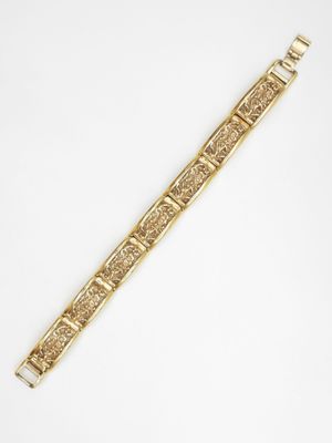a gold bracelet with an intricate design on it