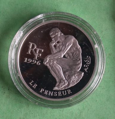 a close up of a coin in a glass container on a green surface