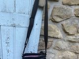 un sac à main noir accroché sur le côté d'une porte