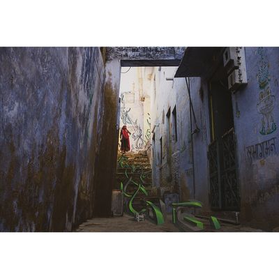 un homme marchant dans une ruelle étroite aux murs couverts de graffitis