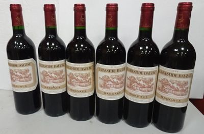 six bottles of red wine are lined up on a table