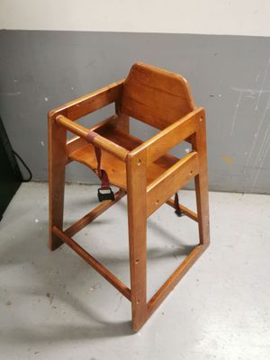 une chaise haute en bois posée par terre