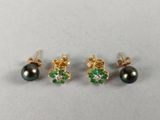 three pairs of black pearls and emerald earrings on a white surface