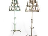 paire de chandeliers anciens en fer forgé avec des bougies posées sur des socles