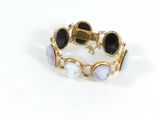 une photo d'un bracelet en or orné de pierres noires et blanches