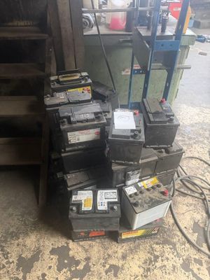 a pile of batteries sitting on the floor next to a pile of boxes