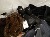 a pile of clothing that is laying on a bed