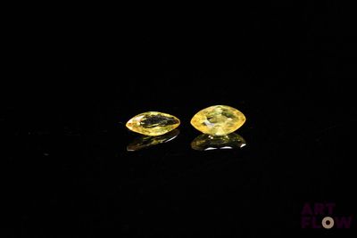 a pair of yellow sapphires on a black surface