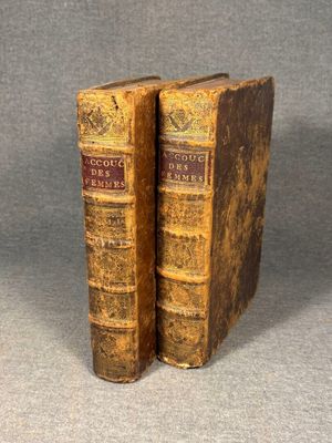two old books sitting on top of each other on a table