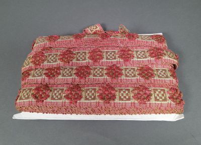 un gros plan d'un sac rose et marron posé sur une surface grise