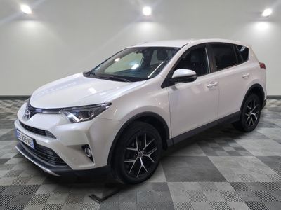 a white toyota rav parked on a checkered floor