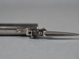 a silver pen with a metal tip sitting on a table