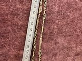 a ruler that is next to a necklace on a table