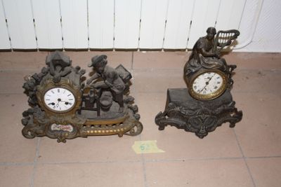 two clocks sitting on the floor next to each other