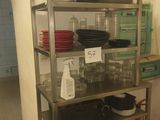 a metal shelf that has many dishes on it