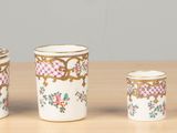 three cups and a container sitting on a table