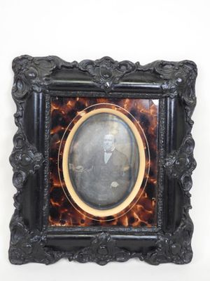 an old picture frame with a picture of a man in a suit