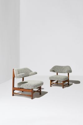 deux chaises et un pouf dans une pièce aux murs blancs