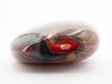 a red and black marble on a white surface