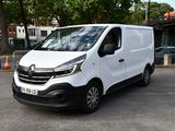 La camionnette blanche est garée sur le parking, près de quelques arbres.