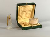 a small glass bottle with a gold lid next to a small glass bottle with a gold lid