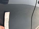 someone is holding a piece of paper that has been taped to the side of a car