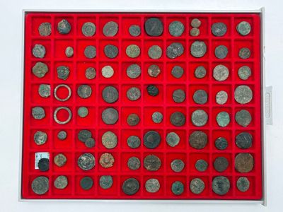 a red display case with a lot of coins in it