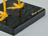 a yellow bird that is standing on a black block