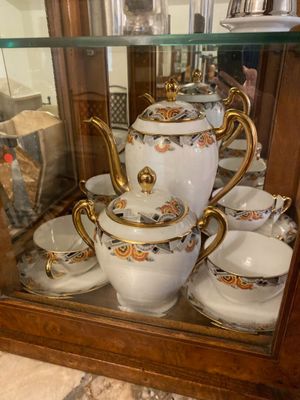 a display case with a tea pot and cups on it