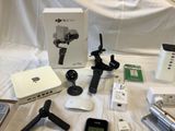 many electronic devices and gadgets laid out on a bed
