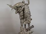 statue of a man and a woman with a bird on a rock