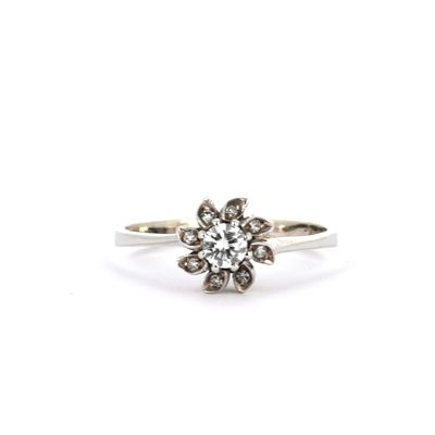 une bague en or blanc sertie de diamants en forme de fleur, sur fond blanc