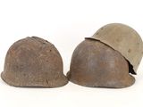 two helmets are sitting next to each other on a white surface