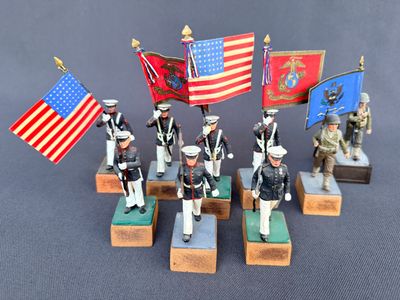plusieurs figurines représentant des militaires tenant des drapeaux et posées sur des socles