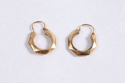 une paire de boucles d'oreilles en or sur fond blanc