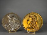 a pair of gold and silver medallions depicting a man and a woman