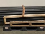 a stack of black pipes on a pallet in a warehouse