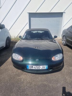 trois voitures garées sur un parking à côté d'un garage