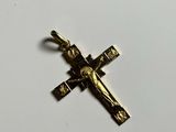 a gold cross with a crucif on it sitting on a white surface
