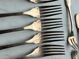 a lot of forks, knives and spoons on the table