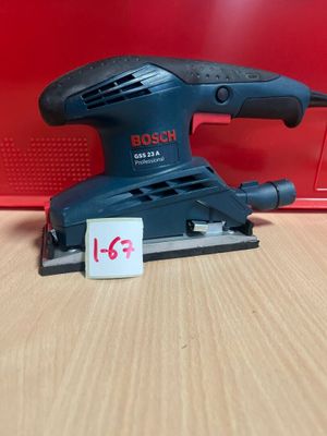 La ponceuse orbitale Bosch est posée sur une table, à côté d'une boîte rouge.