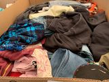a cardboard box filled with clothes and other items