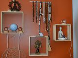 un mur orange sur lequel est posée une étagère remplie de bijoux