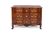 une commode ancienne ornée de sculptures raffinées et dotée de poignées en laiton