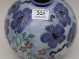 a blue vase with purple flowers on it on a table